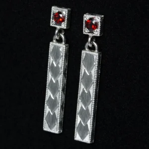 Hopeiset roikkuvat tappikorvakorut punaisilla kivillä ja koristekaiverruksilla.
